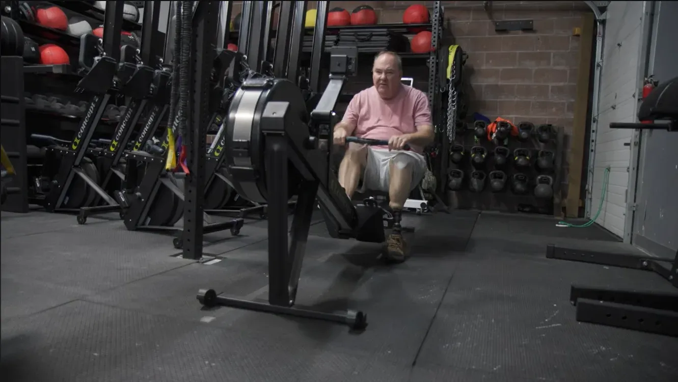 Bill Hancock rowing on a Concept2 erg in the training space at Misfit Gym Windham.