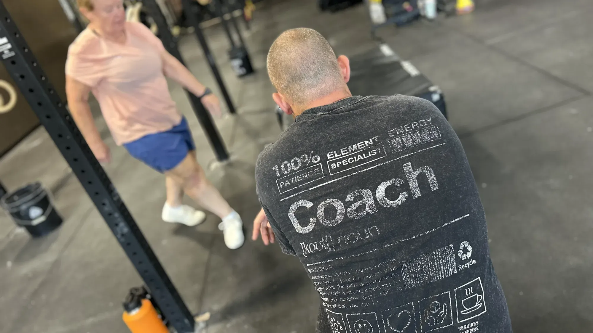 A Misfit Gym Windham coach in a Coach shirt working one-on-one with a member on the training floor