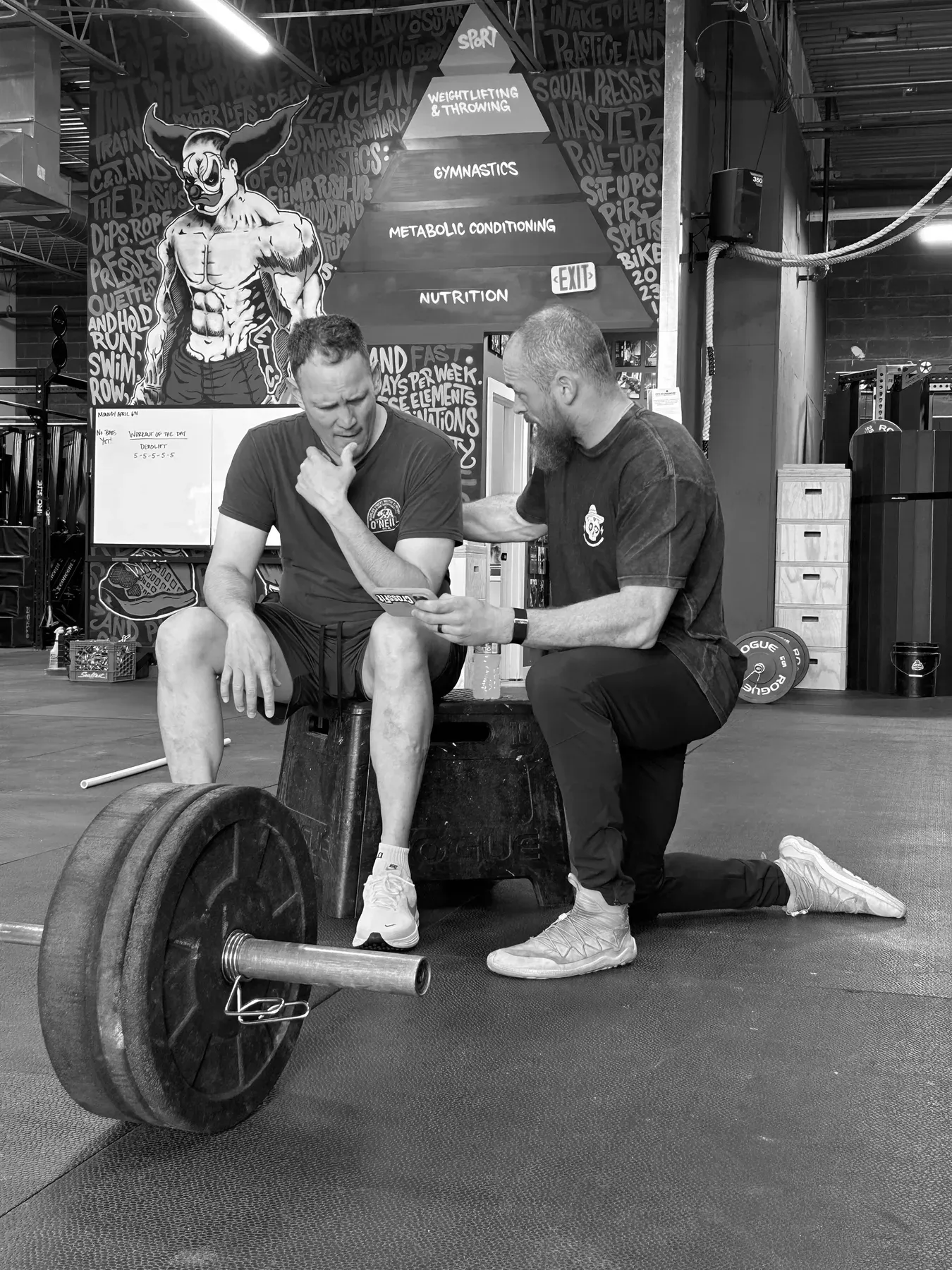 A Misfit Gym Windham coach correcting a member's barbell form one-on-one